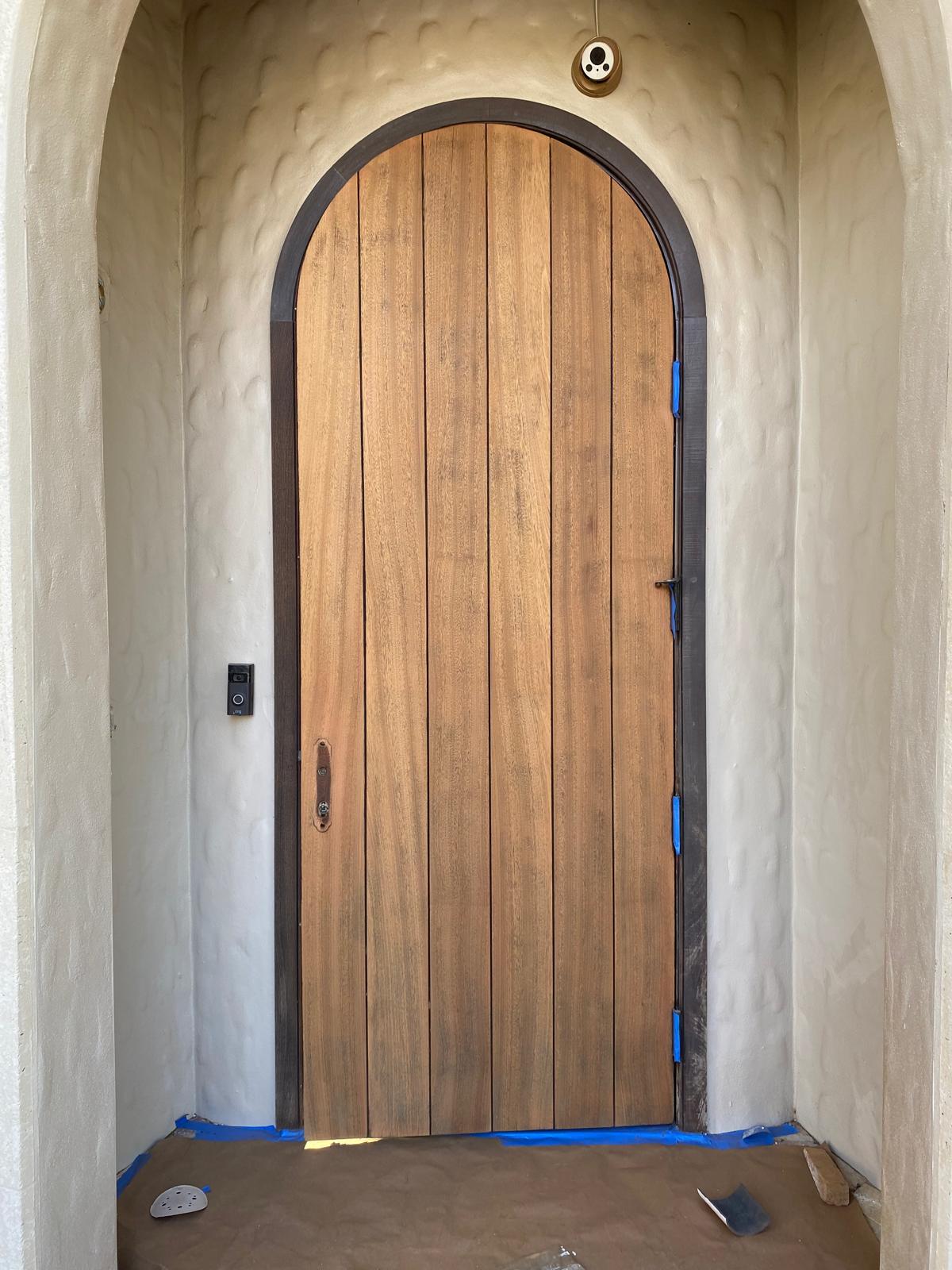 Raw sanded mahogany arched entry door before staining