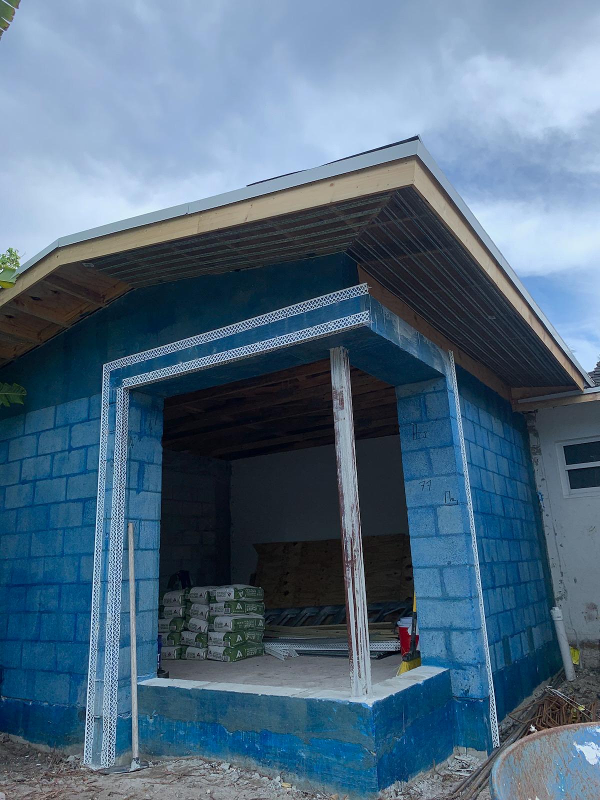 Home addition with completed roof overhang and block walls sealed before stucco