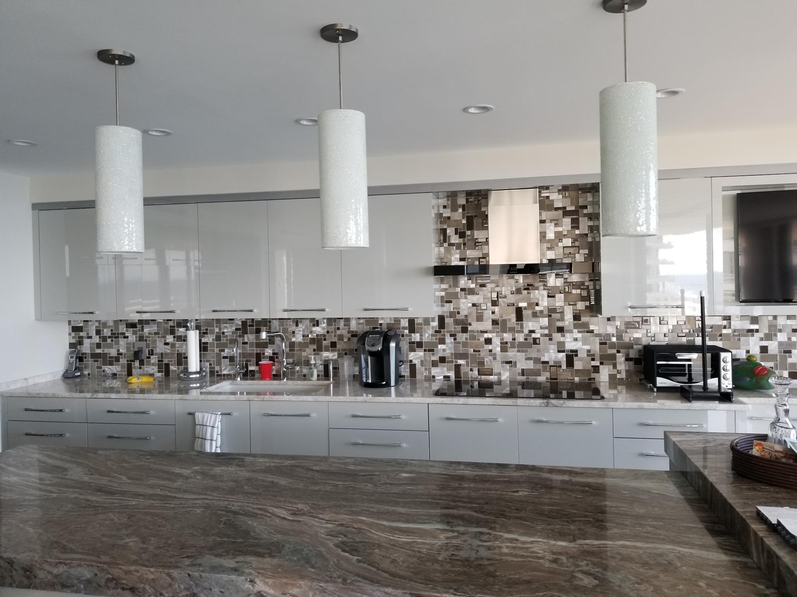 Sleek gloss kitchen with metallic mosaic backsplash and granite island