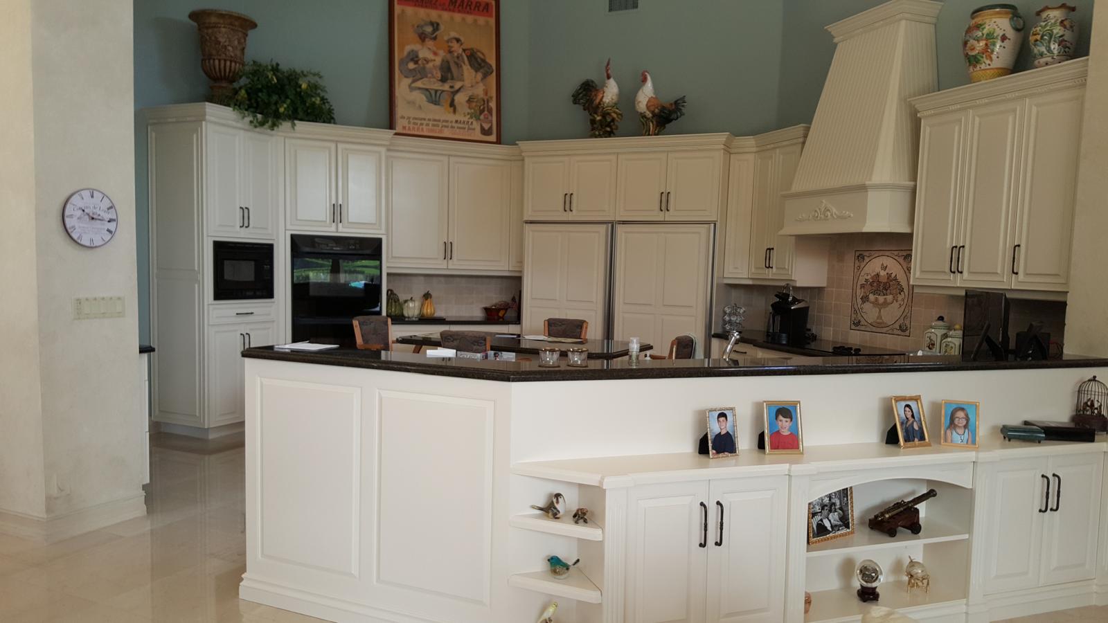 Classic ivory kitchen with decorative range hood and granite peninsula