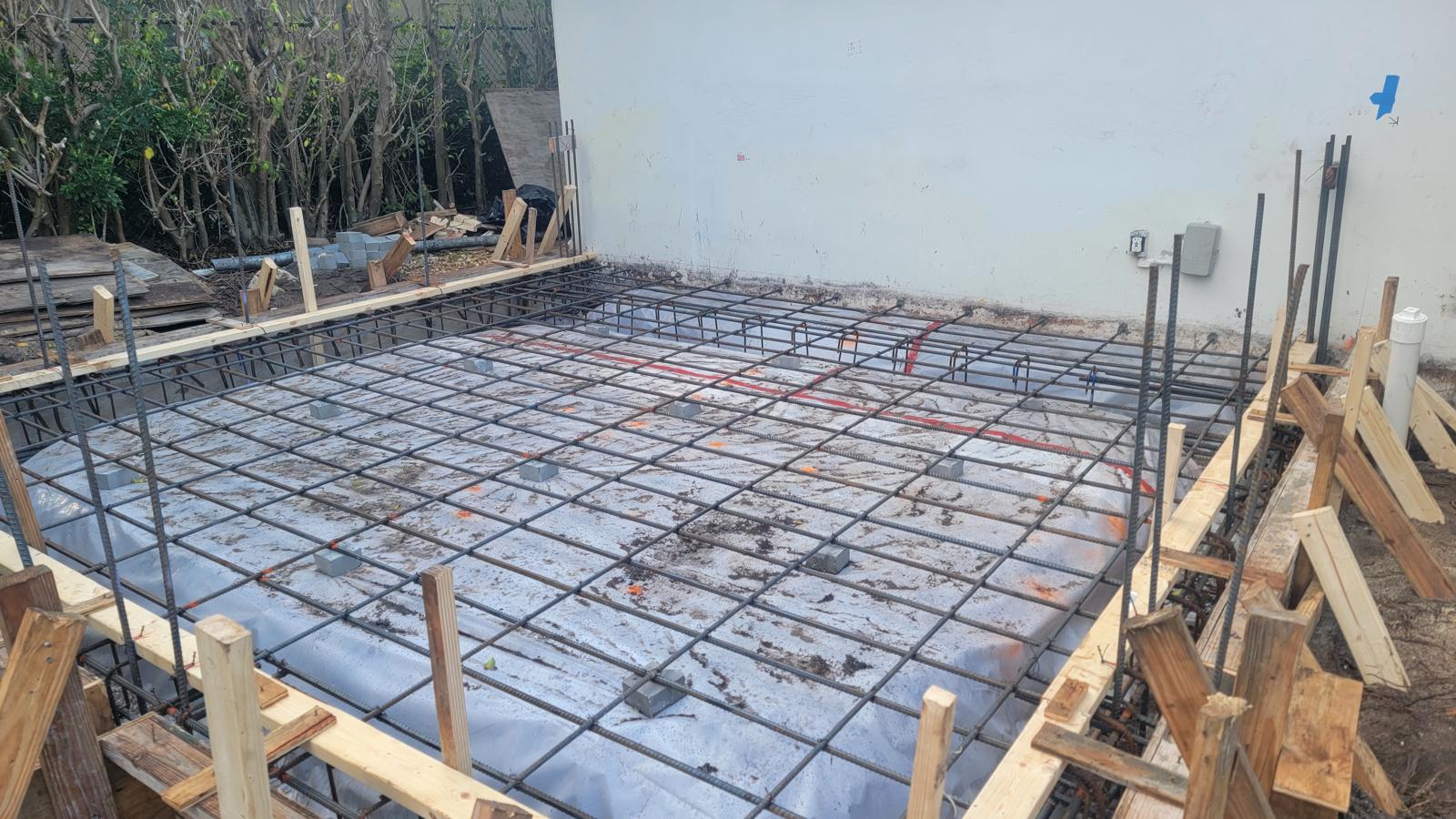 Reinforced rebar grid and vapor barrier prepared for a home addition slab pour