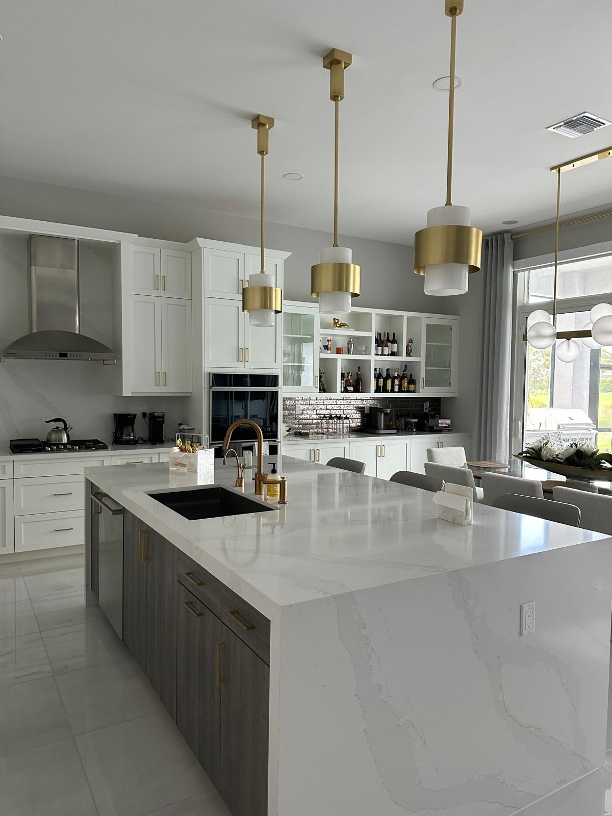 Luxury modern kitchen with white marble island and brass pendant lights