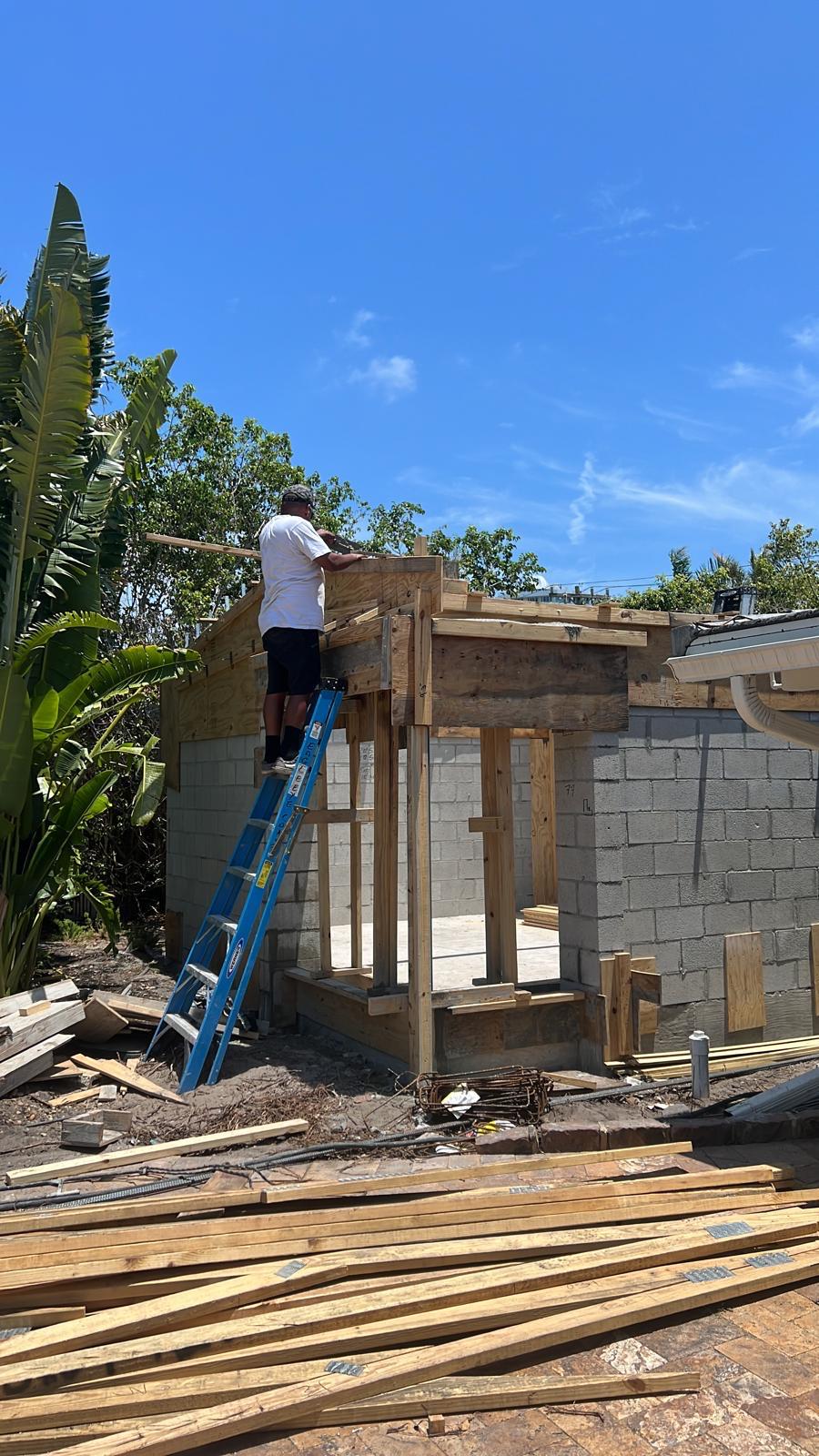 Carpenter framing the roof structure of a home addition