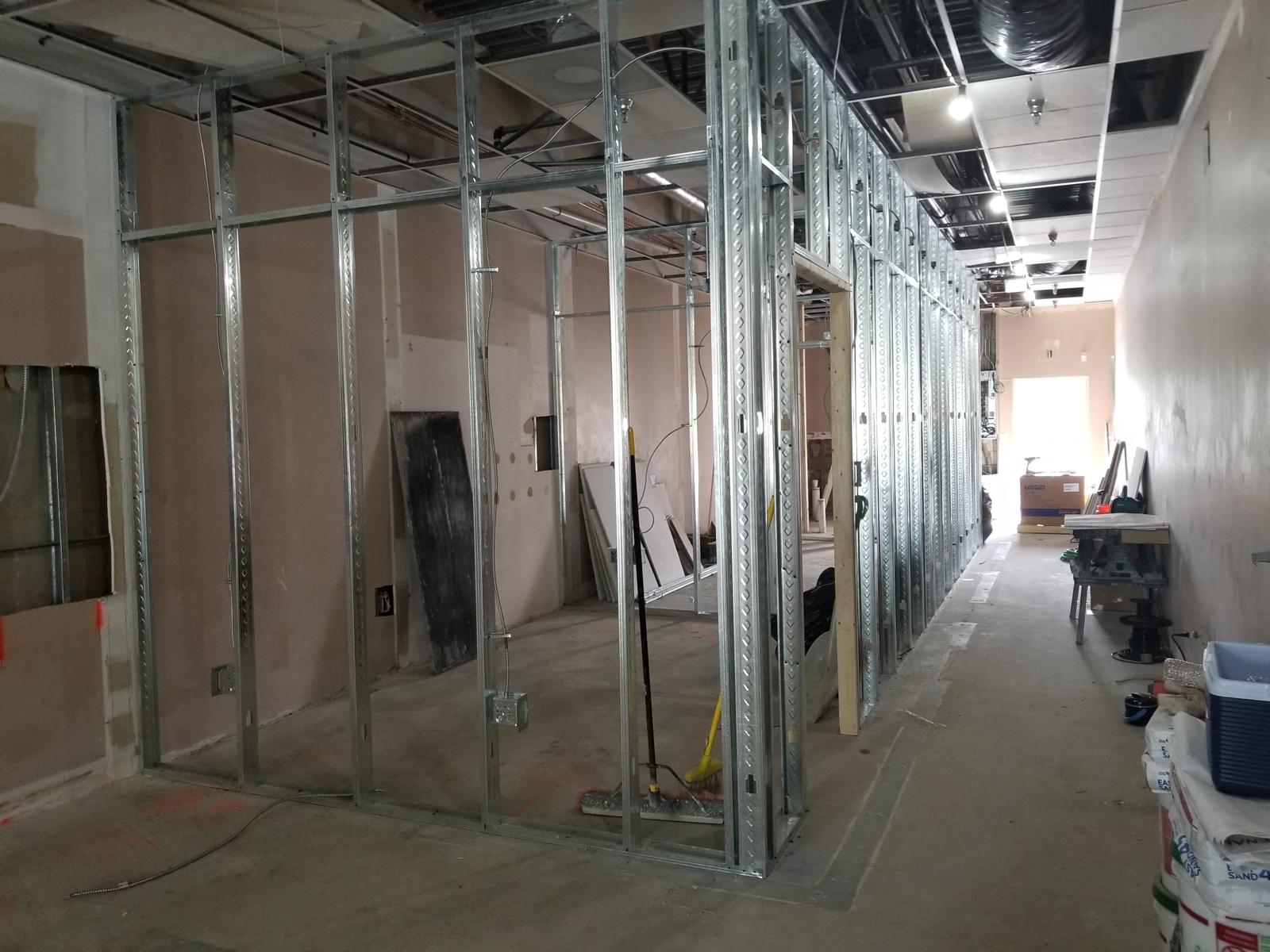 Rows of light-gauge metal studs and drywall partitions in a retail build-out
